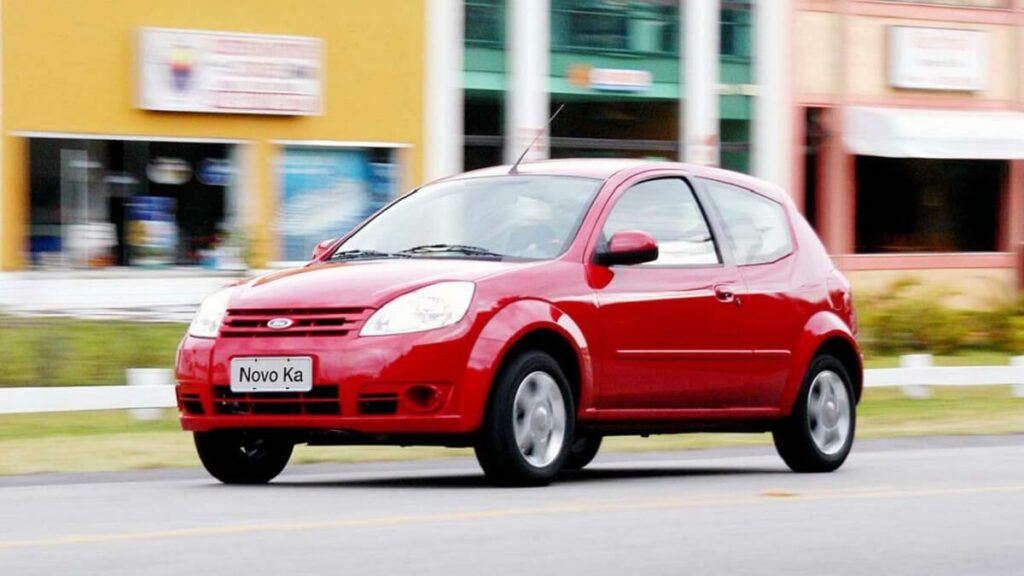 Ford Ka vermelho andando em uma rua com prédios ao fundo
