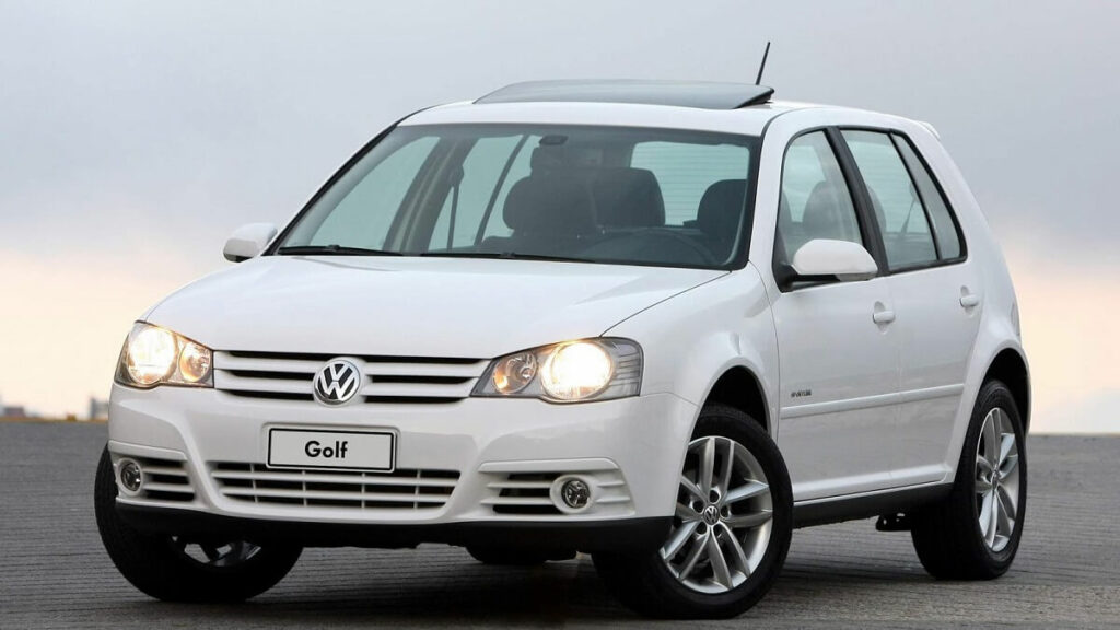 Foto de um Golf 2010 branco com os Faróis acesos