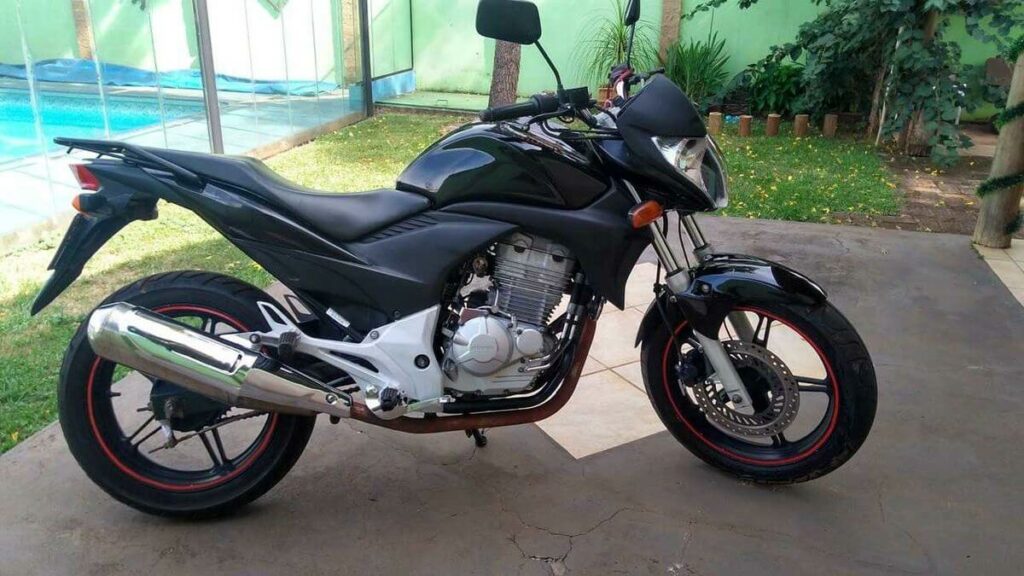 Foto lateral de uma Honda 300 CB 2011 preta estacionada em uma garagem