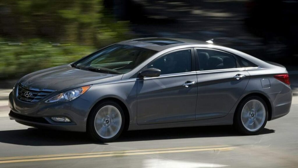 Sonata 2012 escuro andando em estrada com árvores ao fundo