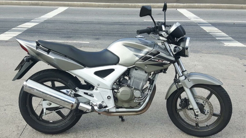 Foto de uma Twister 2008 prata com detalhes em preto estacionada na rua