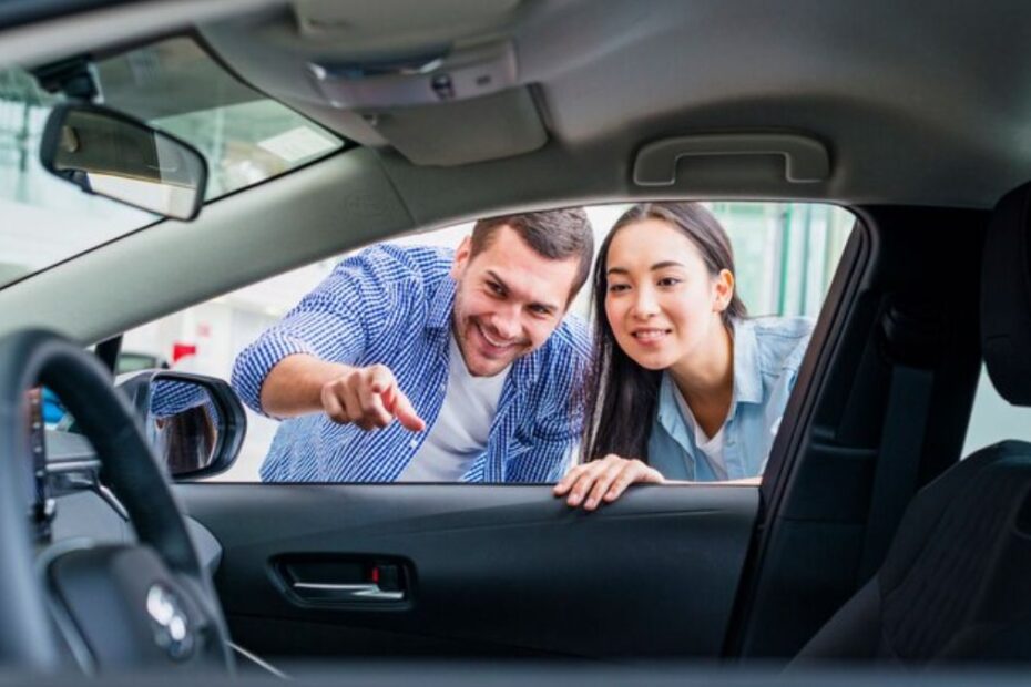 Casal olhando interna de carro.