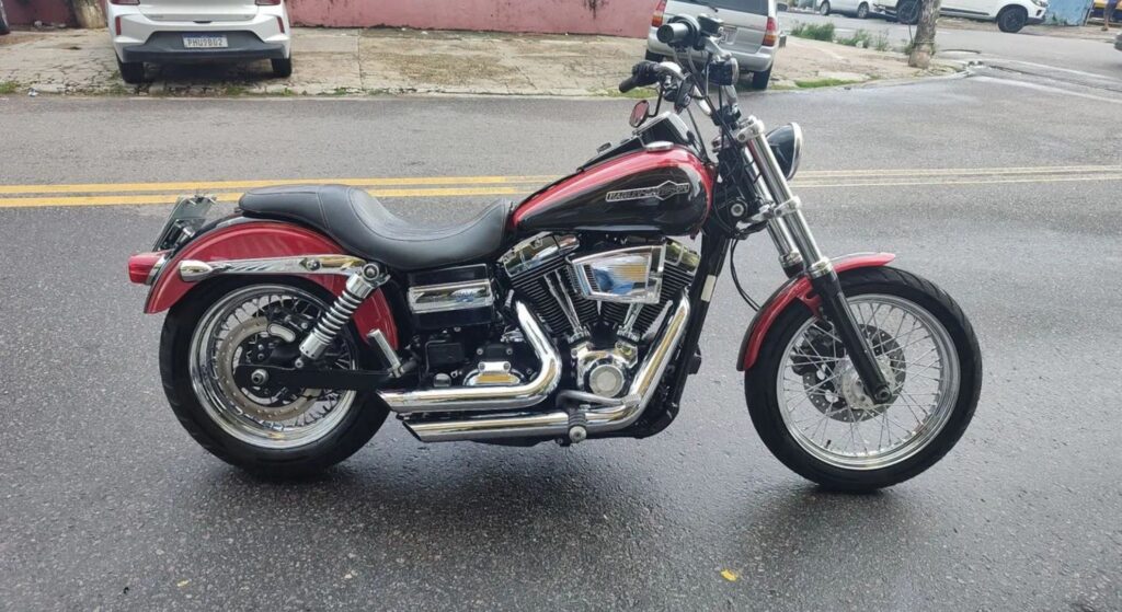 Harley-Davidson Dyna 2012 perto e vermelha parado de lado.