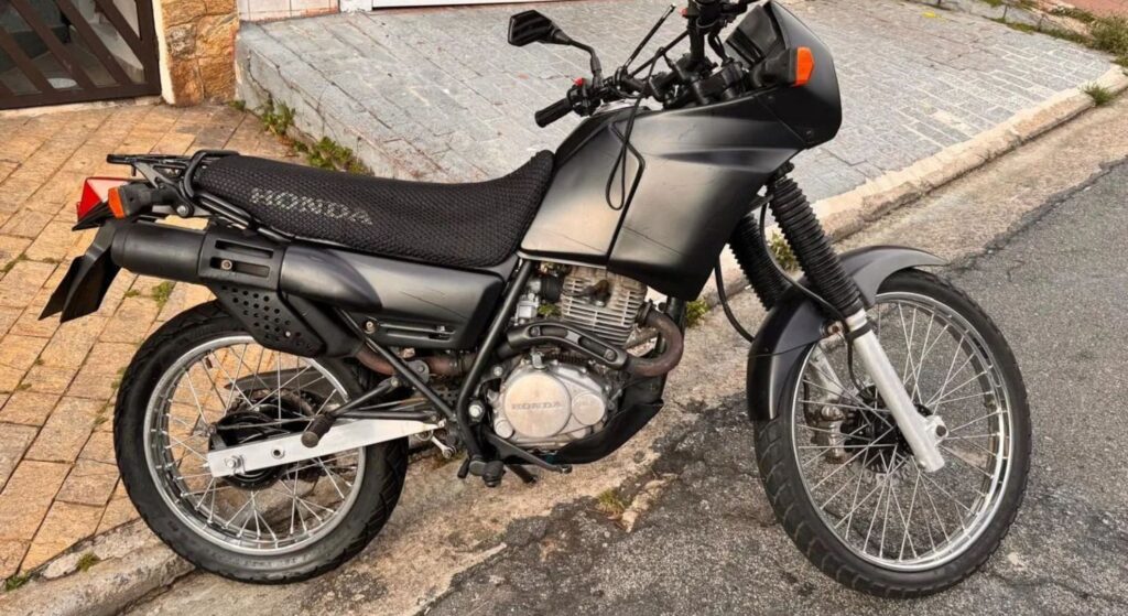 Honda NX 200 1993 prata de lado.