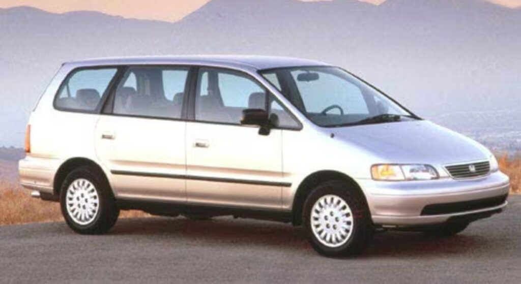 Honda Odyssey 1998 prata parado de lado.