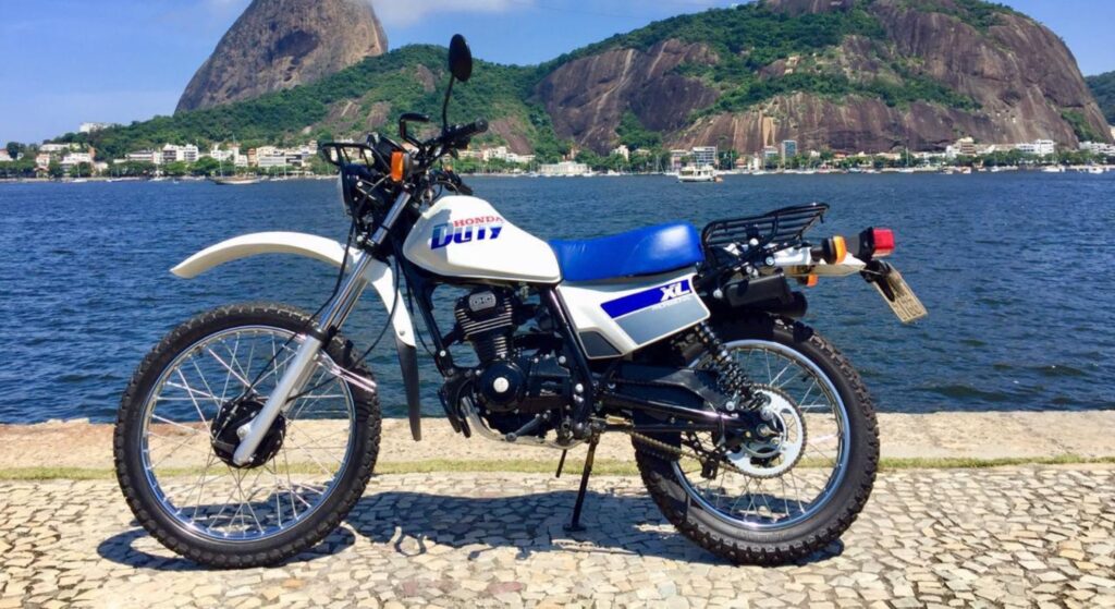 Honda XL 125 1991 branca de lado.