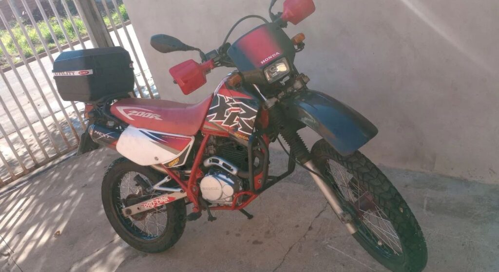 Honda XR 200 R 1995 vermelha parado na diagonal.