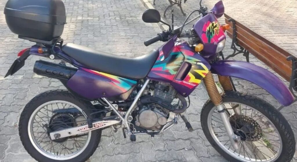 Honda XR 200 R 1998 roxo parado na diagonal.