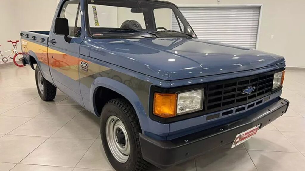 Chevrolet D-20 1985 azul com detalhes em laranja, preto, e vermelho na diagonal.