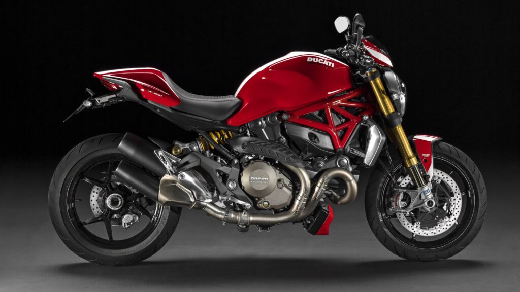 Lateral da DUCATI MONSTER 2016 vermelha no fundo escuro.