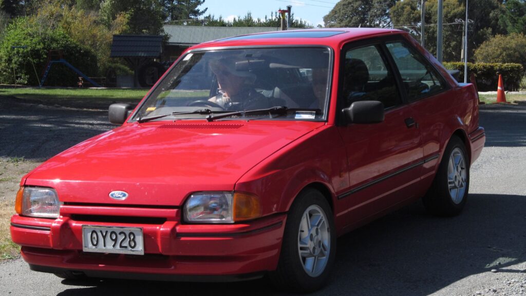 Ford Escort 1986 vermelho na diagonal.