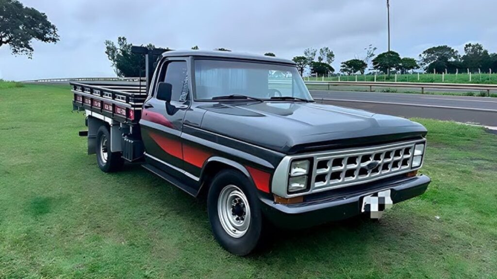 FORD F-2000 1985 cinza com detalhes em vermelho.
