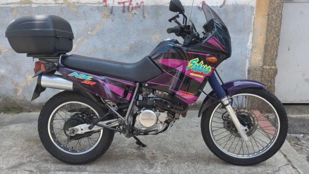HONDA NX 350 SAHARA 1999 roxa com rosa e preto de lado.