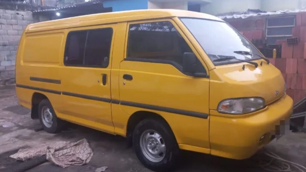 Hyundai H100 2004 amarela parada na diagonal.