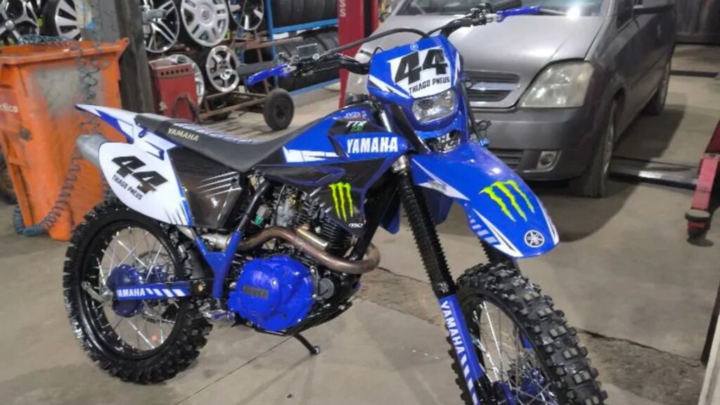 Yamaha TT-R 230 2010 azul com preto na diagonal em um oficina.