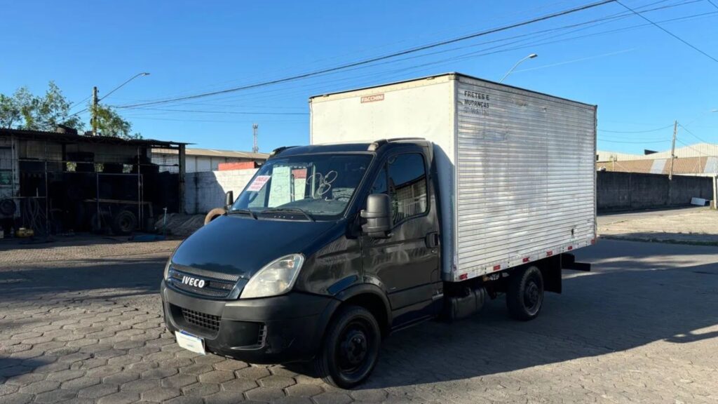 IVECO DAILY 2008 cinza escuro com baú parado na diagonal.