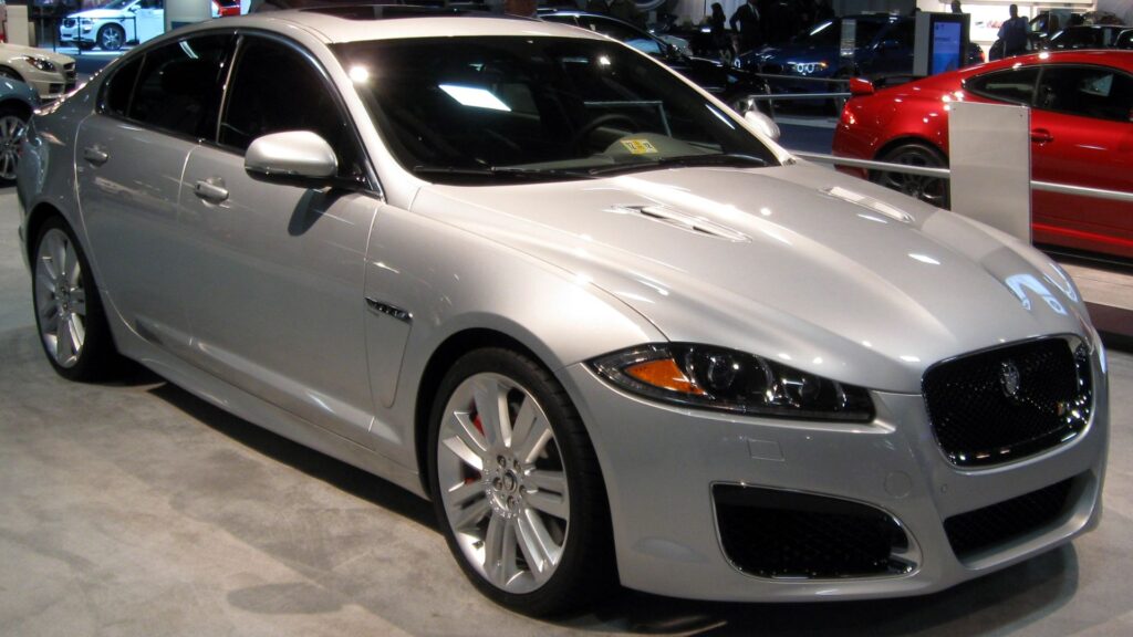 Jaguar XF 2012 prata parado na diagonal.