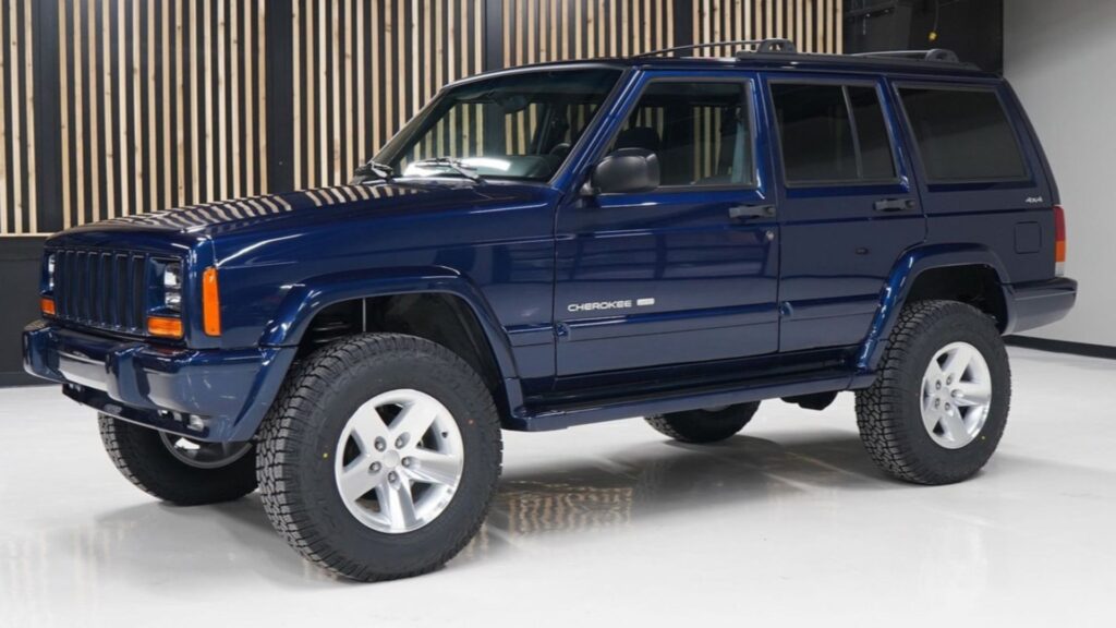 Jeep Cherokee 2001 azul parado na diagonal.