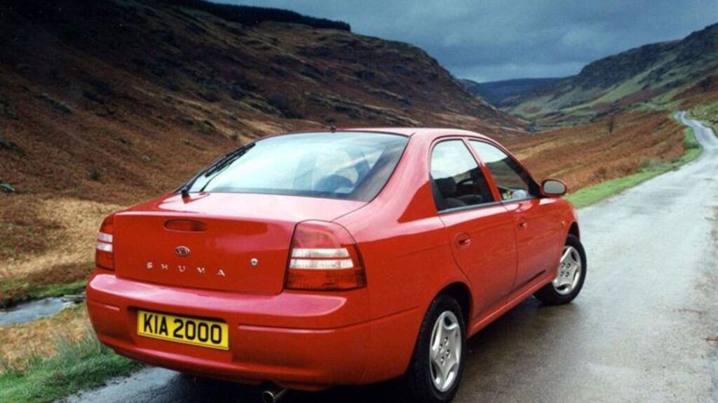 Traseira do Kia Motors Shuma 1999 vermelho parado em uma estrada.