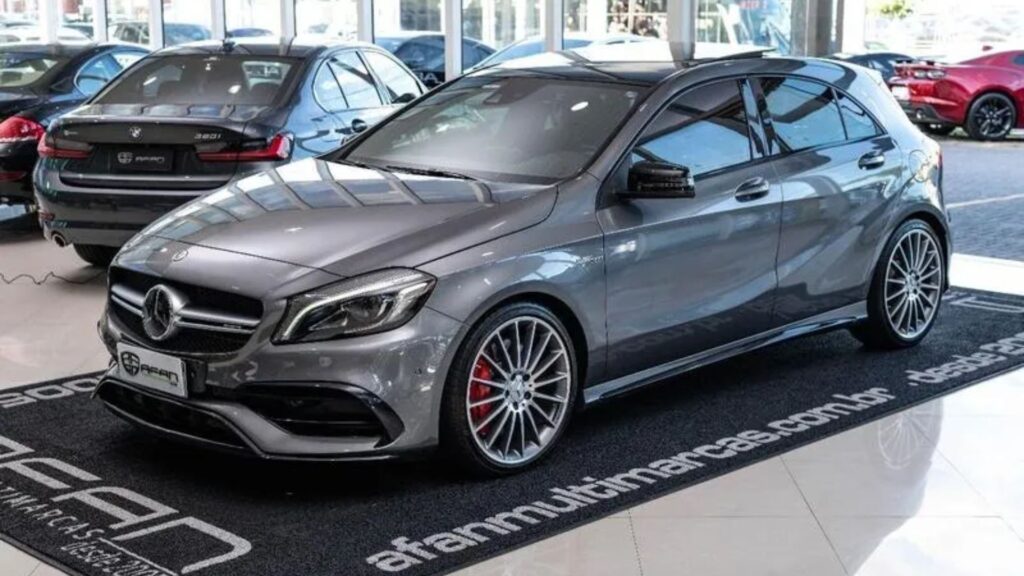 Mercedes-Benz Classe A45 2018 cinza escuro parada em cima de um tapete na diagonal em um loja de carro.