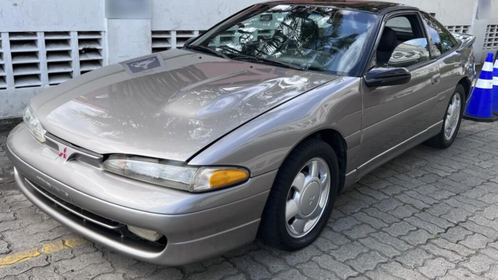  Mitsubishi Eclipse 1994 cinza na diagonal parado em uma vaga de carro.