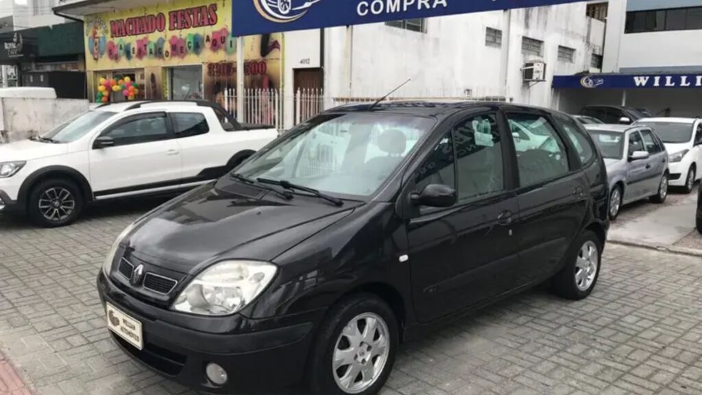 Renault Scénic 2011 preto parado na frente de uma concessionaria.