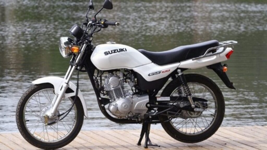 SUZUKI GS 120 2016 branca parada de lado próxima de um rio.