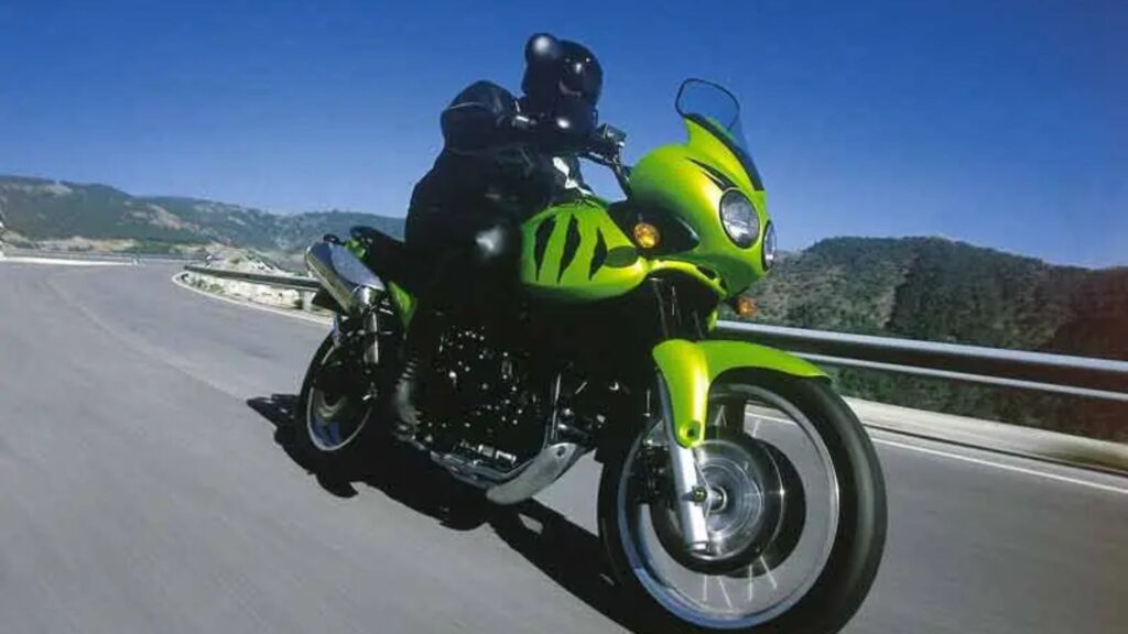 TRIUMPH TIGER 955i 2002 verde na estrada com um motociclista em cima.