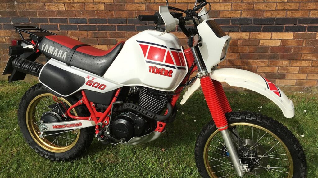 YAMAHA XT 600 1991 branca parada do lado de um muro.