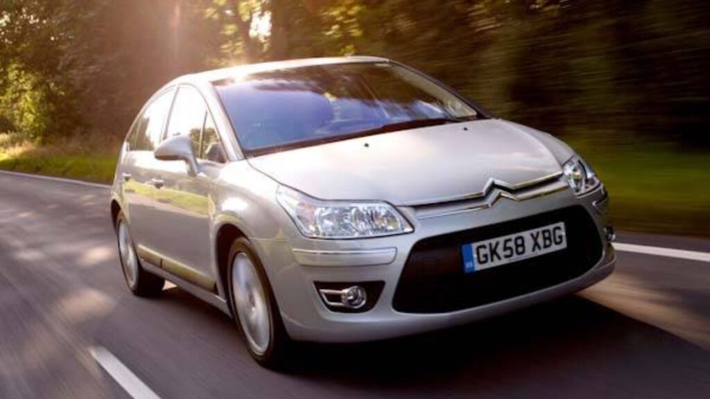 Citroën C4 2010 prata em movimento na estrada.