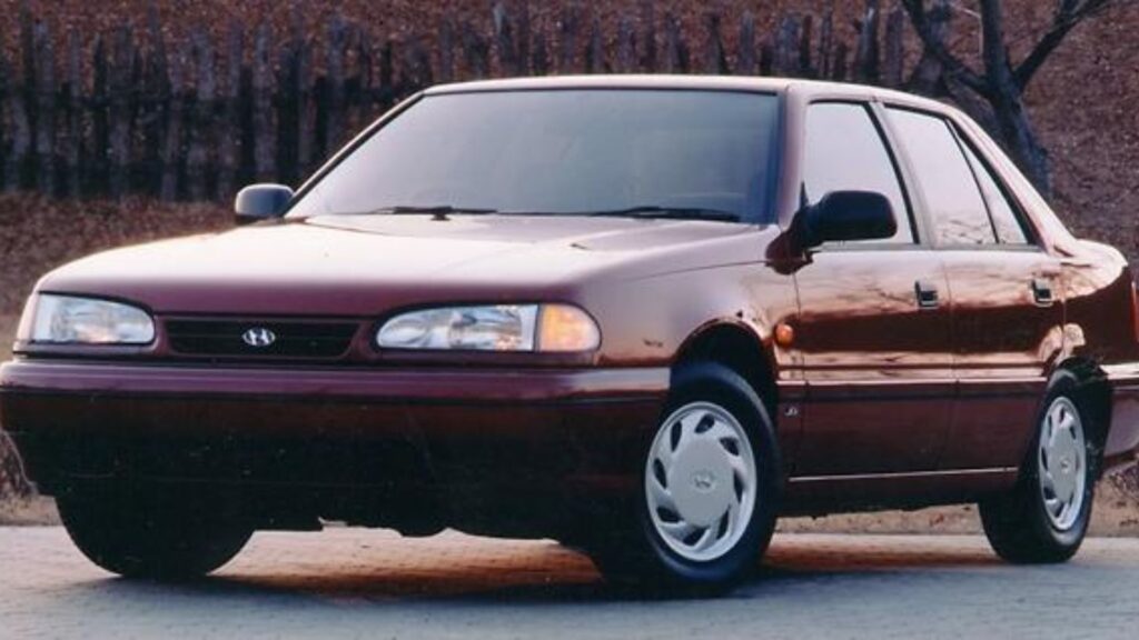 Hyundai Sonata 1992 vermelho parado na diagonal.