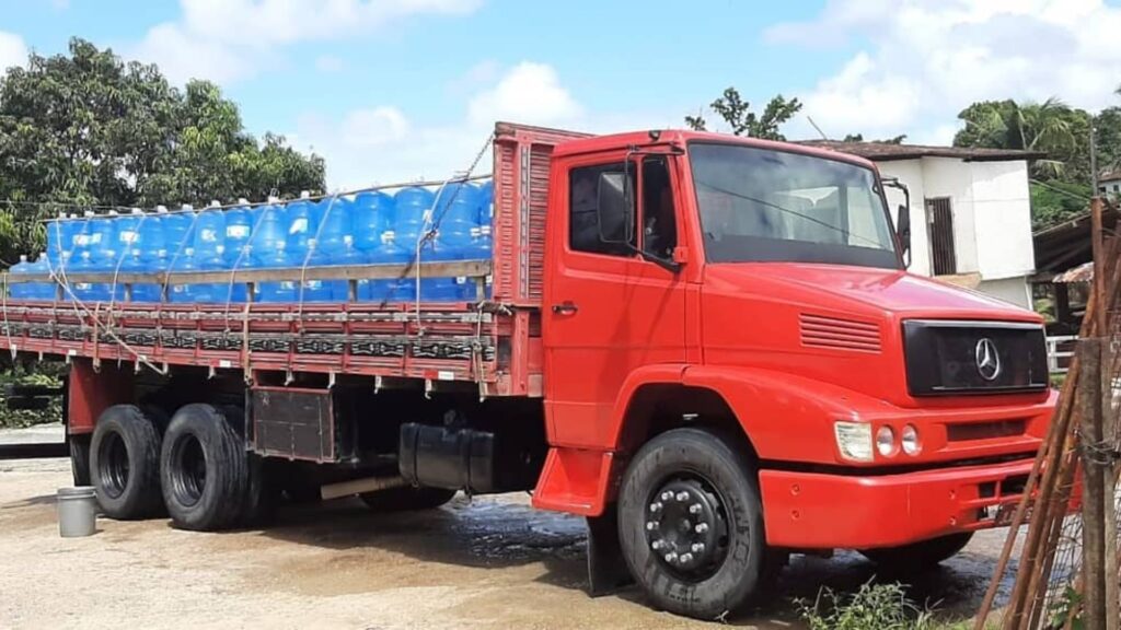 MERCEDES-BENZ 1418 1994 vermelho parado na diagonal com várias garrafas de 15 litros de agua.