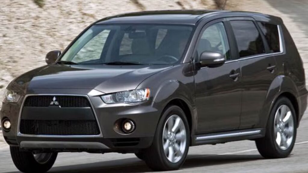 Mitsubishi OUTLANDER 2011 marrom em movimento na estrada.
