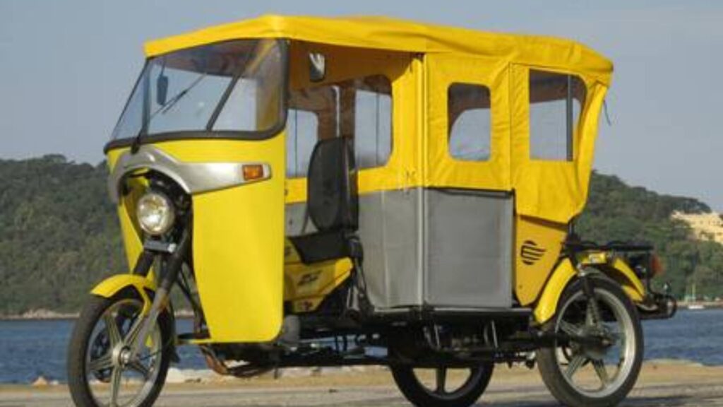 MOTOCAR MTX-150 2016 amarela paradna diagonal com um rio no fundo.