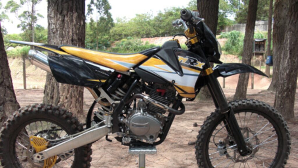 MRX 230R 2009 preta com amarelo parada de lado.