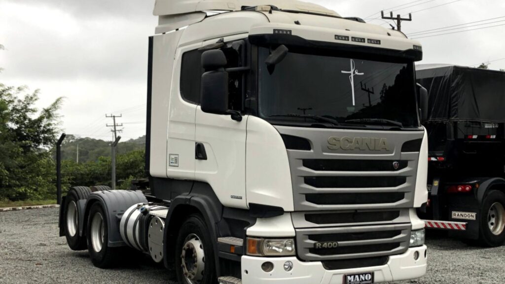 SCANIA R-400 2015 branca parada na diagonal em um pátio do lado de outros caminhões.