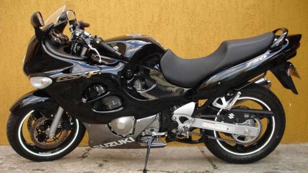 Lateral da SUZUKI GSX 750 F 1999 preta parada em uma parade laranja.
