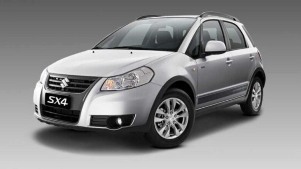 Suzuki SX4 2015 prata parado na diagonal em um fundo cinza.
