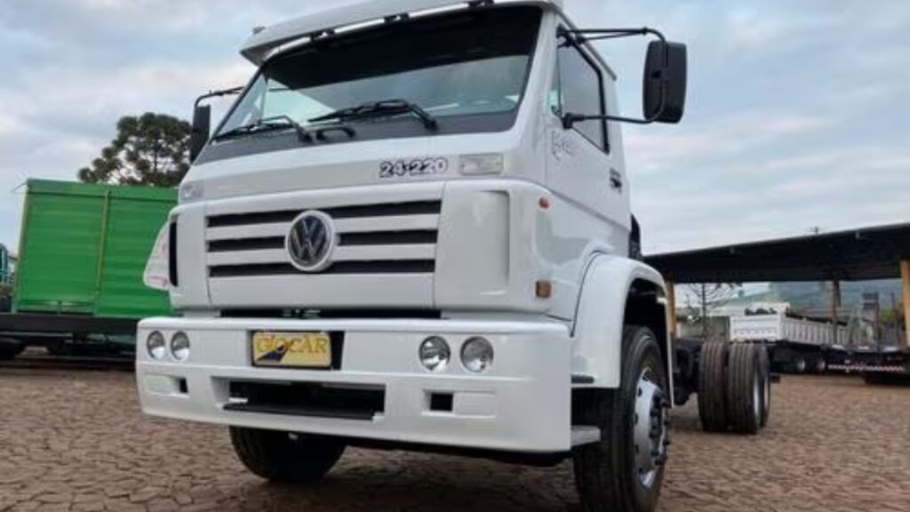VOLKSWAGEN 24-220 2012 branco parado na diagonal no meio de um pátio.