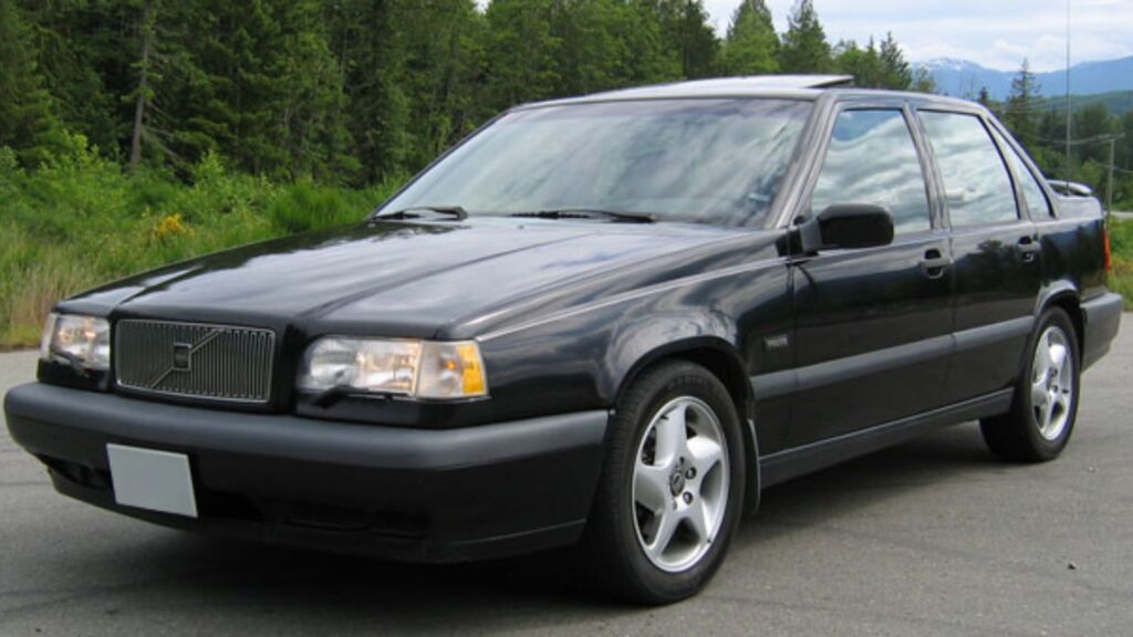 Volvo 850 1996 preto parado na diagonal no meio da estrada.