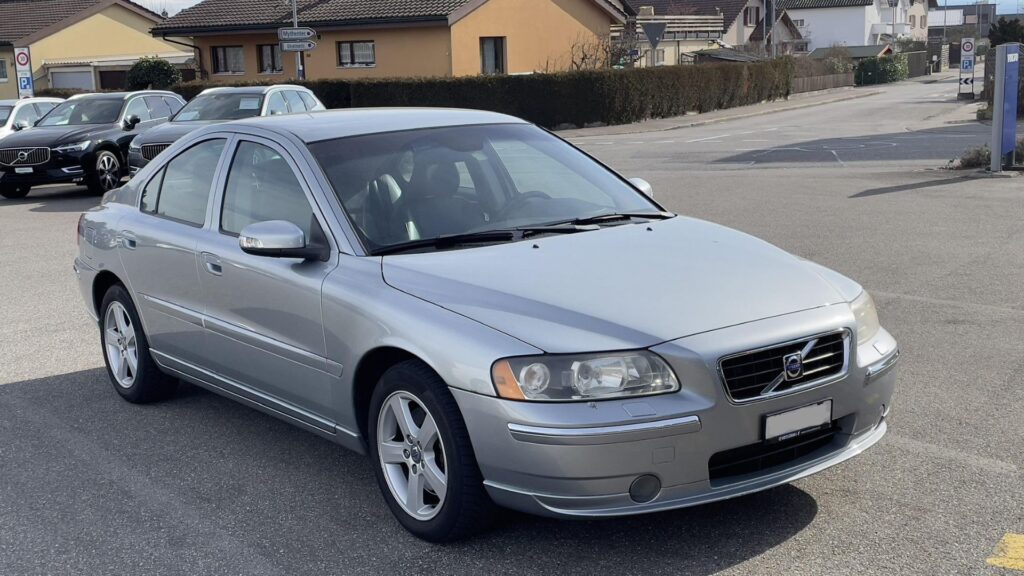 Volvo S60 2006 prata parado na estrada.