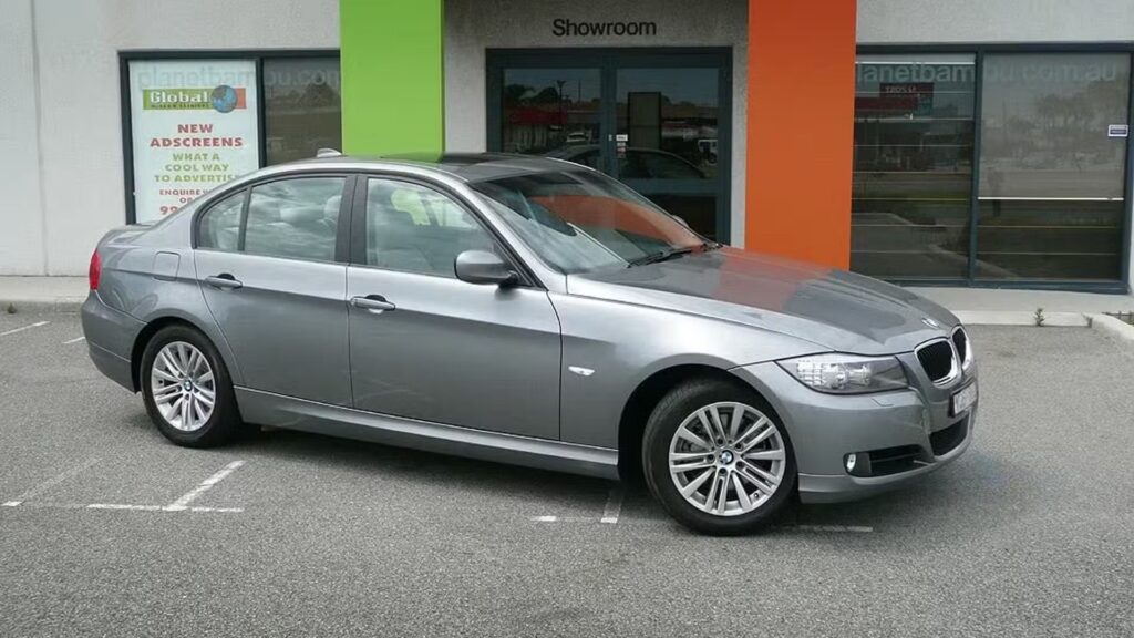 BMW 320iA 2009 cinza parada na diagonal.