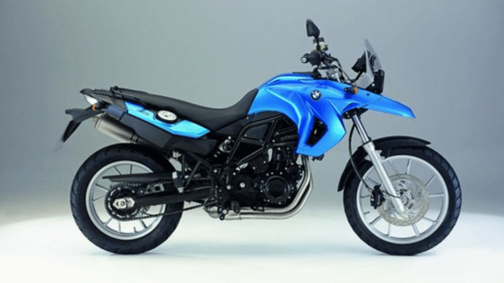 BMW F 650 2011 azul parada de lado em um fundo cinza.