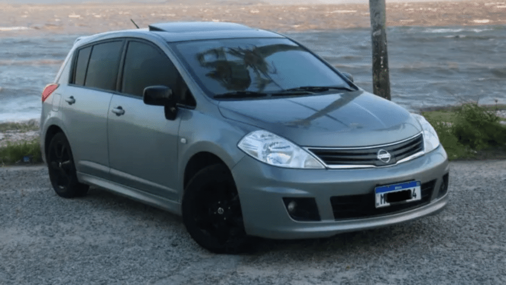 Nissan TIIDA 2013 cinza parado na diagonal.