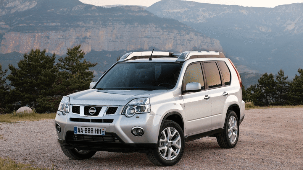 Nissan X-TRAIL 2007 prata parado na diagonal.