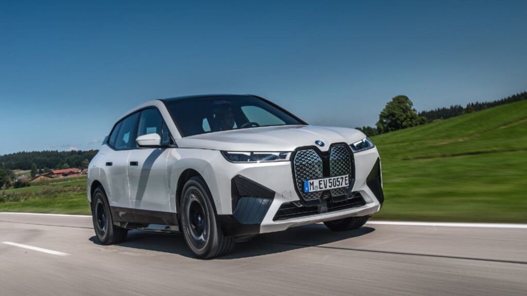 BMW iX 2023 branco acelerando na estrada.