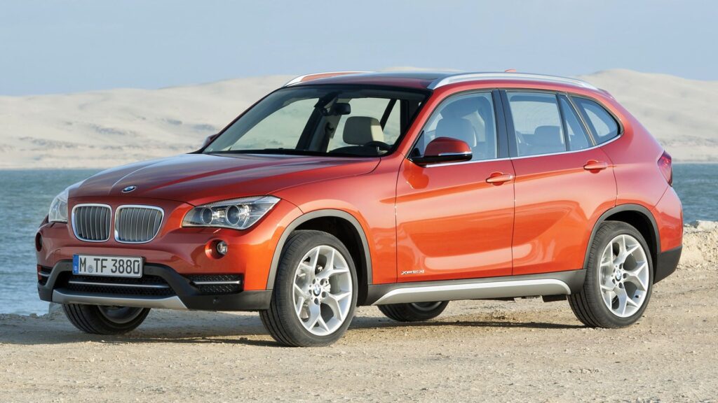BMW X1 2015 laranja parada na diagonal.