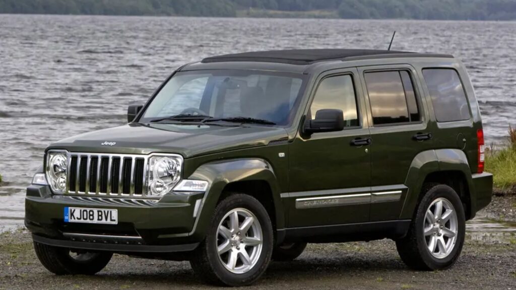 Jeep Cherokee 2010 verde parado na diagonal.