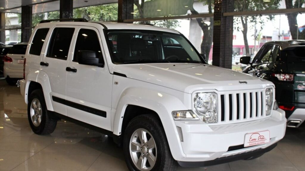 Jeep Cherokee 2011 branco parado na diagonal.