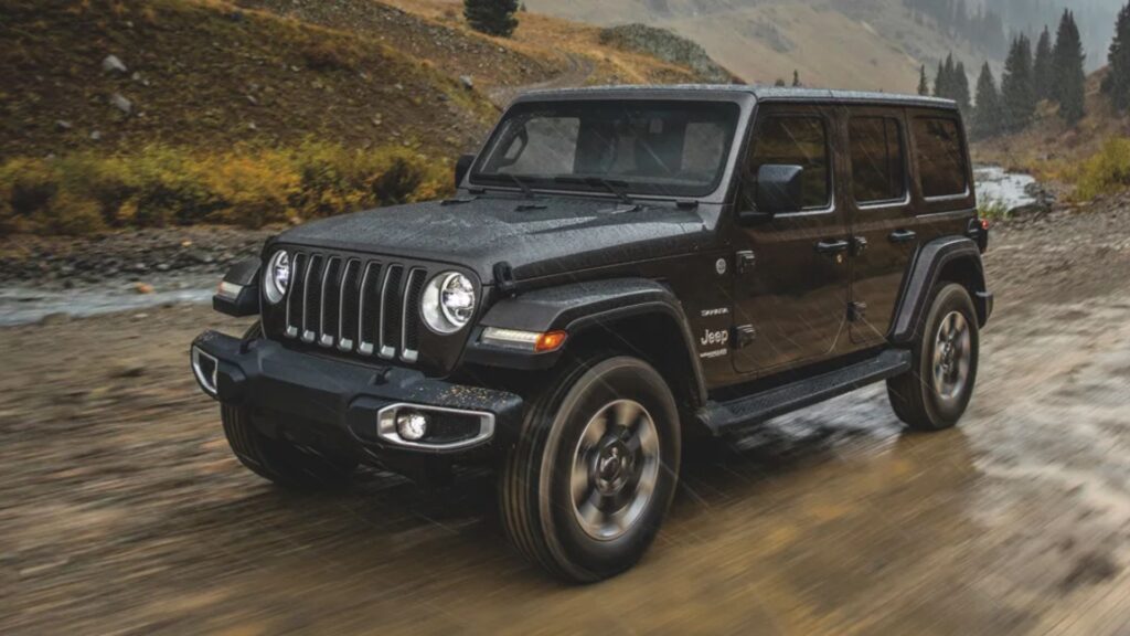 Jeep Wrangler 2000 preta em movimento na estrada de chão.